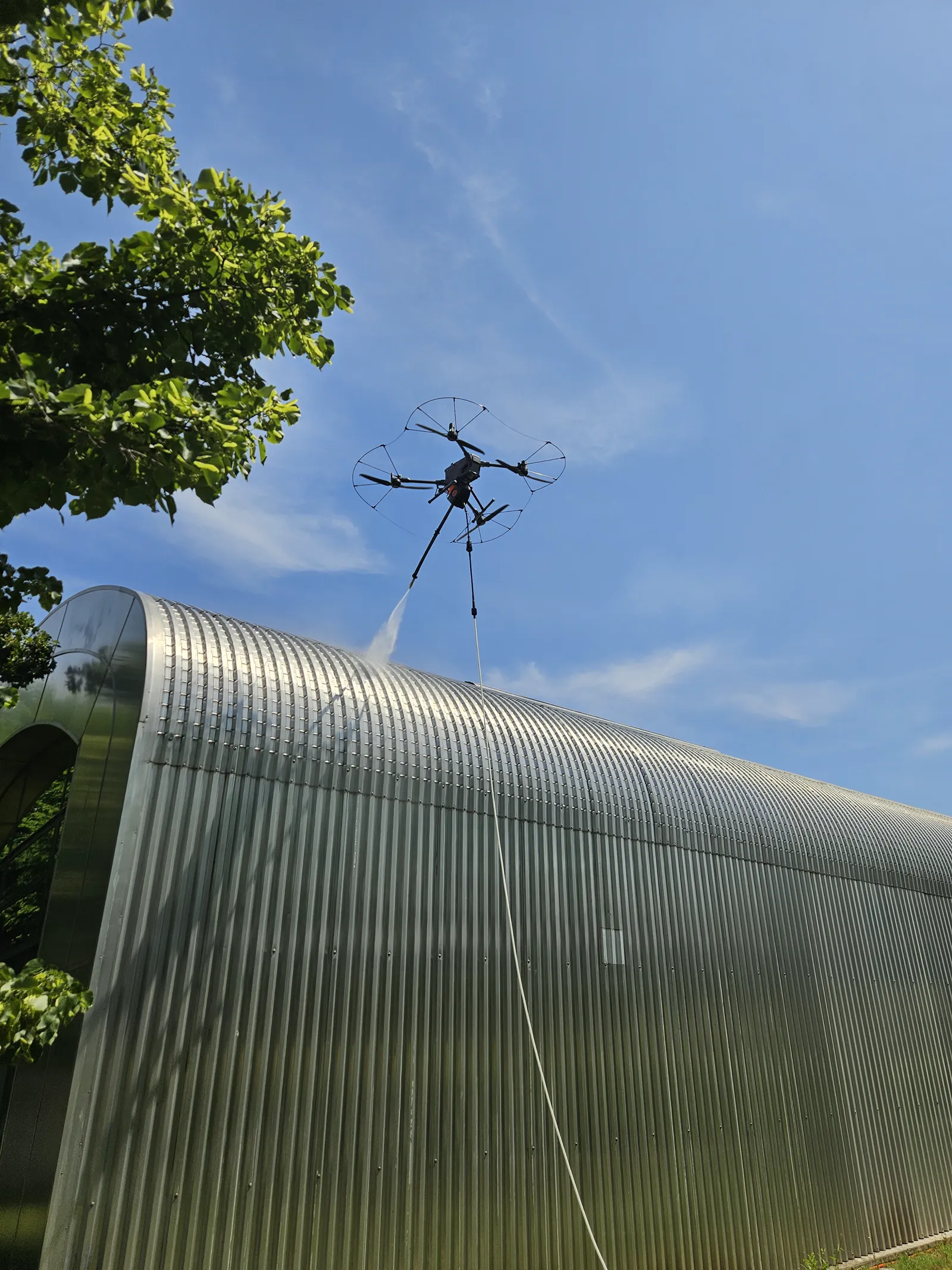 Dron s nastavkom za pranje čisti limenu fasadu objekta
