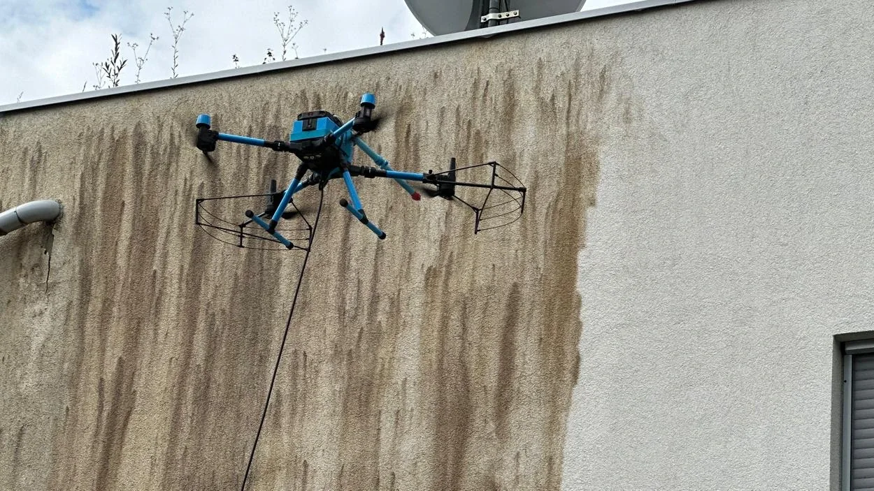 Dron s nastavkom za pranje čisti zaprljanu žbukanu fasadu